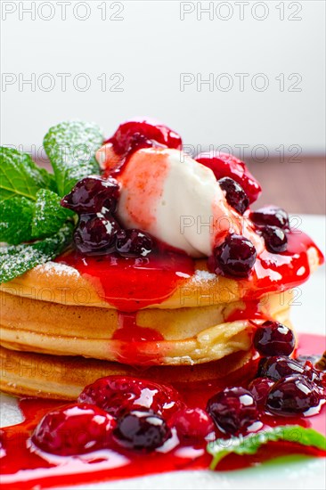 Macro photo of pancakes with strawberry and black currant jam