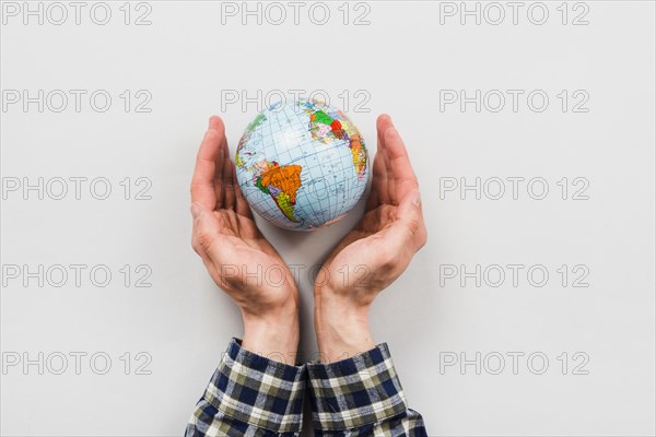 Earth globe surrounded by hands