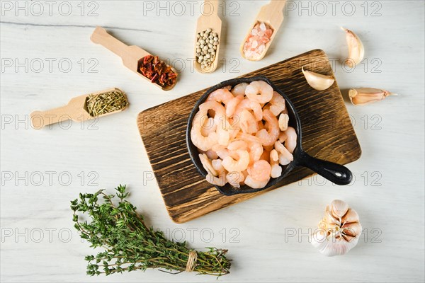 Overhead view of frozen peeled shrimps in frying pan