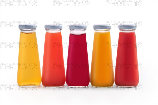 Assorted juices in small glass bottles isolated on white background