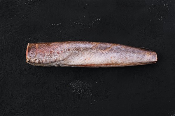 Raw frozen hake on black background