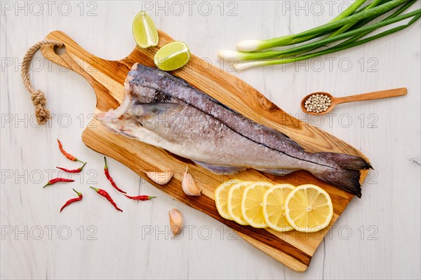 Top view of raw fresh haddock carcass on wooden cutting board