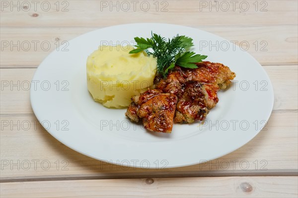 Portion of delicious fried meat in honey sauce with mashed potato