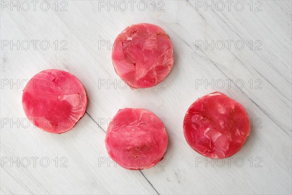 Fresh raw round tuna cutlet on wooden background