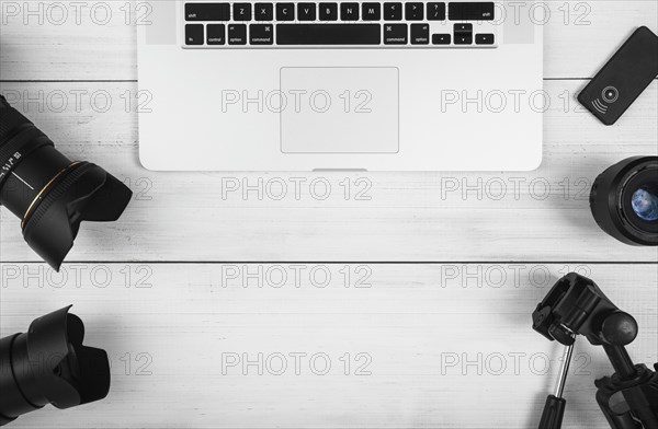 Overhead view laptop with camera accessories white desk