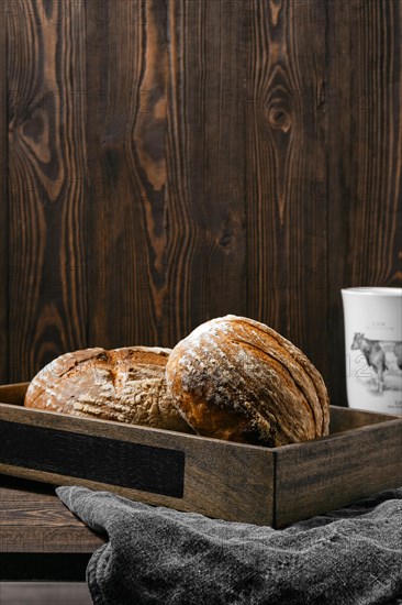 Two loafs of artisan whole grain wheat bread on wooden table