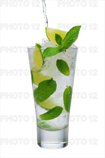 Pouring tonic into highball glass with ice crush