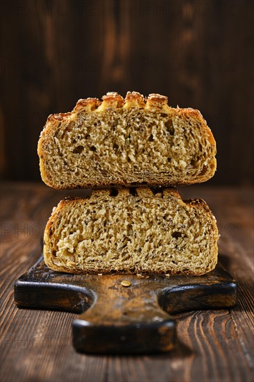 Fresh oats bread with sunflower seeds and sesame on wooden table