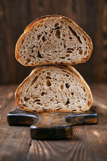 Loaf of artisan sourdough bread with porous texture cut on half