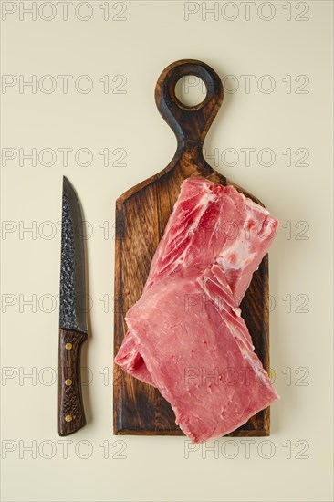 Top view of raw pork tenderloin on wooden cutting board