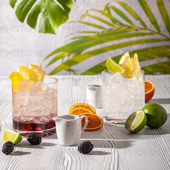 Espresso-tonic refreshing drink with different fruits and syrups on wooden table under morning sun