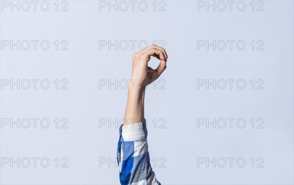 Hand gesturing the letter O in sign language on an isolated background. Man's hand gesturing the letter O of the alphabet isolated. Letter O of the alphabet in sign language