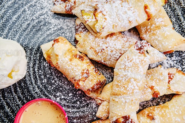 Top view of baked pear wrapped in pastry with cinnamon served with ice cream