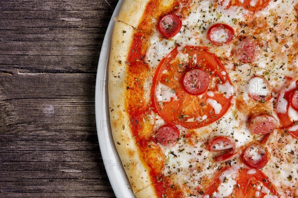 Part of pepperoni pizza on wooden table