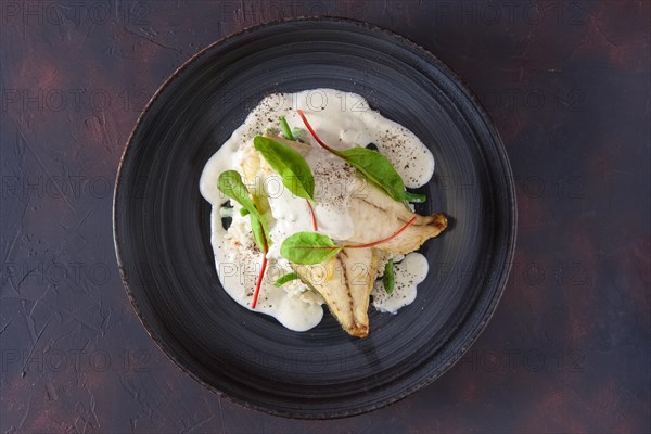 Fried fillet of white fish with rice and green beans decorated with chard