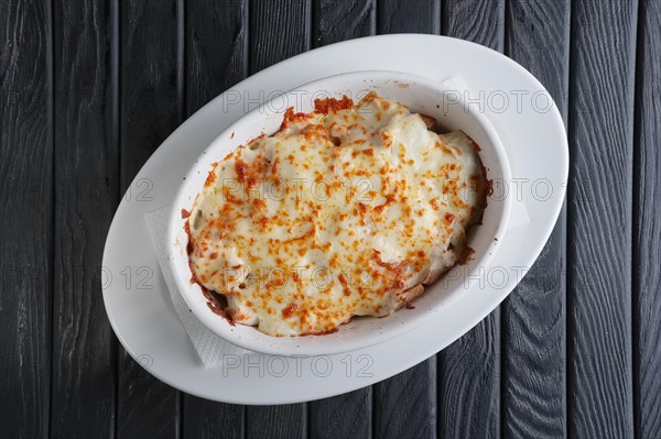 Lasagna Italian cuisine. Top view. Plate on a wooden background