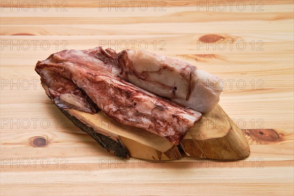 Frozen fresh octopus or squids raw on wooden board