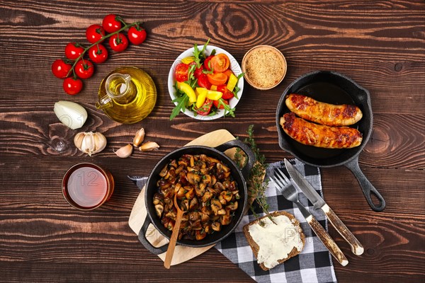 Fried mushrooms and sausage in cas-iron skillet. Ingredients for rustic simple food