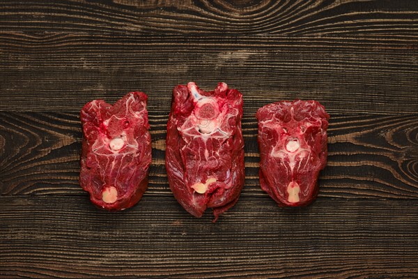 Overhead view of raw fresh deer neck over dark wooden background