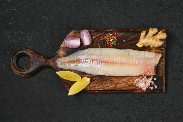 Top view of freshly frozen zander fillet on wooden cutting board