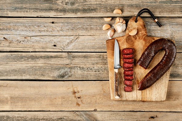 Top view of smoked dried beef sausage on wooden cutting board