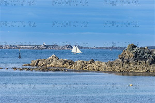 Sailing boat behind huge granite rocks