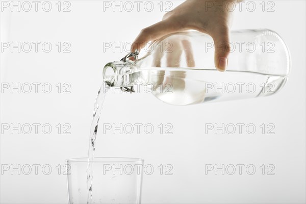 Pouring water from bottle into glass