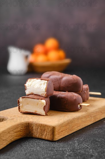 Homemade curd bars in chocolate on wooden board