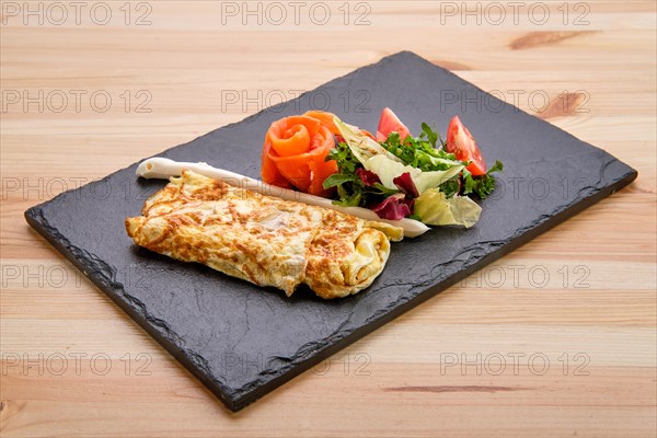 Omelette with salmon on slate plate