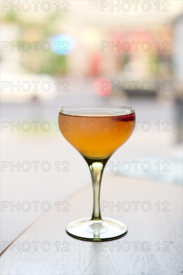 Soft focus photo of cocktail Dragon eye on terrace table with blurred city on background