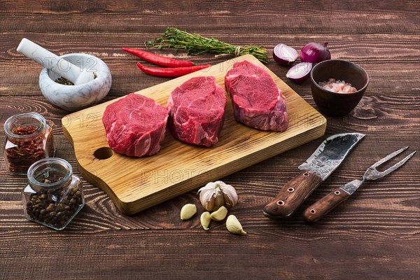 Marinated raw beef steak with spice on wooden table