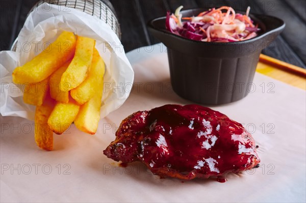 Rustic lunch. Grilled ribs with fried potato and red cabbage salad