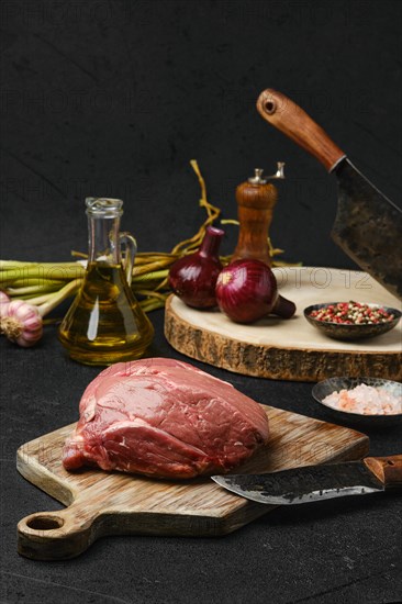 Raw beef petite sirloin with ingredients on black background