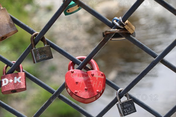 Many colorful metal love padlocks on fence