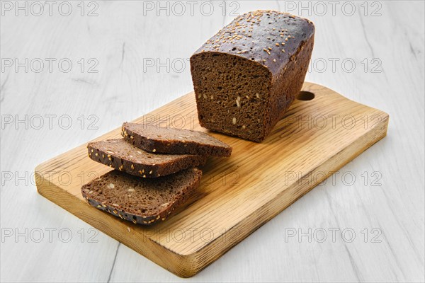 Top view of loaf of brown sourdough bread with sunflower seeds and sesame