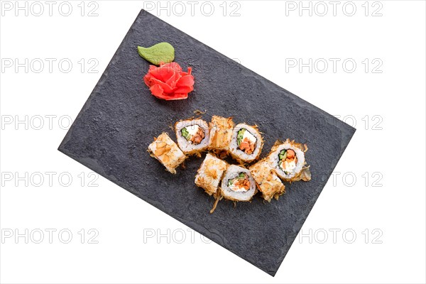 Smoked salmon rolls with cucumber on slate plate isolated on white