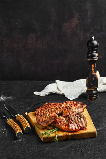 Juicy steak on wooden cutting board over black background