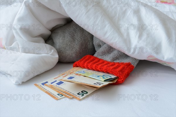 Banknotes in stocking under duvet