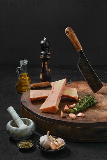 Large beef bone marrow chopped on half with spice on wooden stump