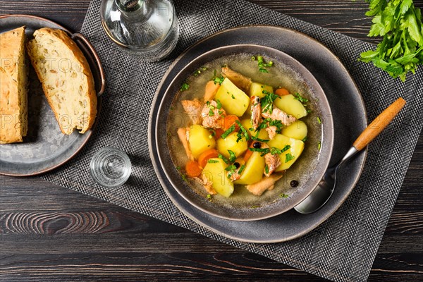 Top view of red salmon fish soup with potato and carrot