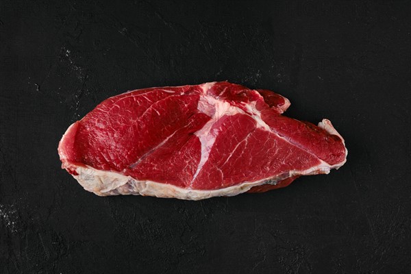 Top view of raw top sirloin beef steak on wooden cutting board