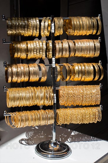 Shop display of dozens of golden bracelets and bangles