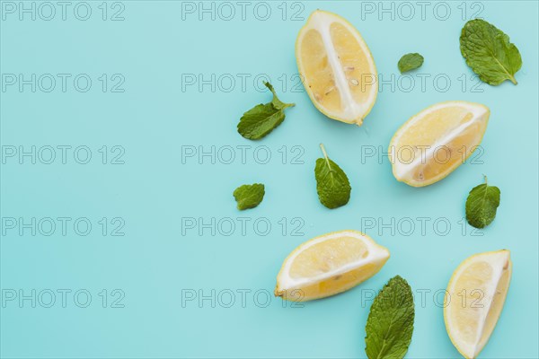 Lemon wedges mint leaves background