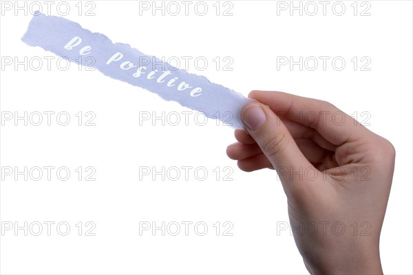 Hand holding torn notepaper with be Positive thinking concept label