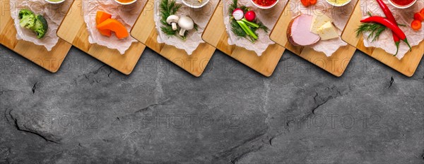 Variety of colorful vegetables and ingredients for cream soups top view on stone background