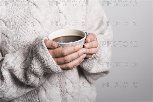 Mid section woman woolen clothes holding coffee cup