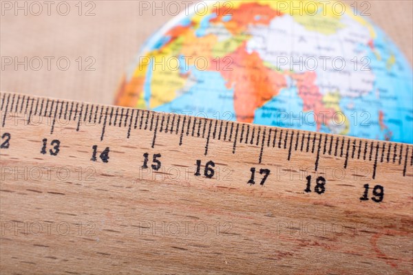 Model globe placed beside a wooden ruler