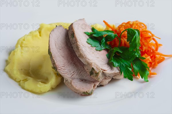 Plate with oven made pork with mashed potato and spicy carrot