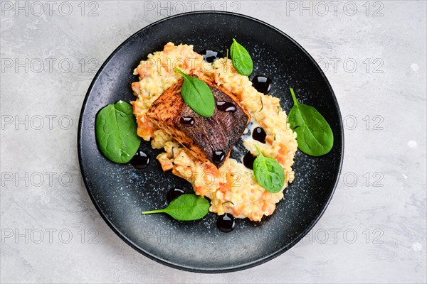 Top view of fried salmon steak served with bulgur and sweet potato on a plate