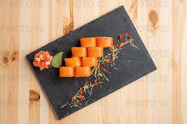 Set of rolls with wasabi and pickled ginger on stone serving board